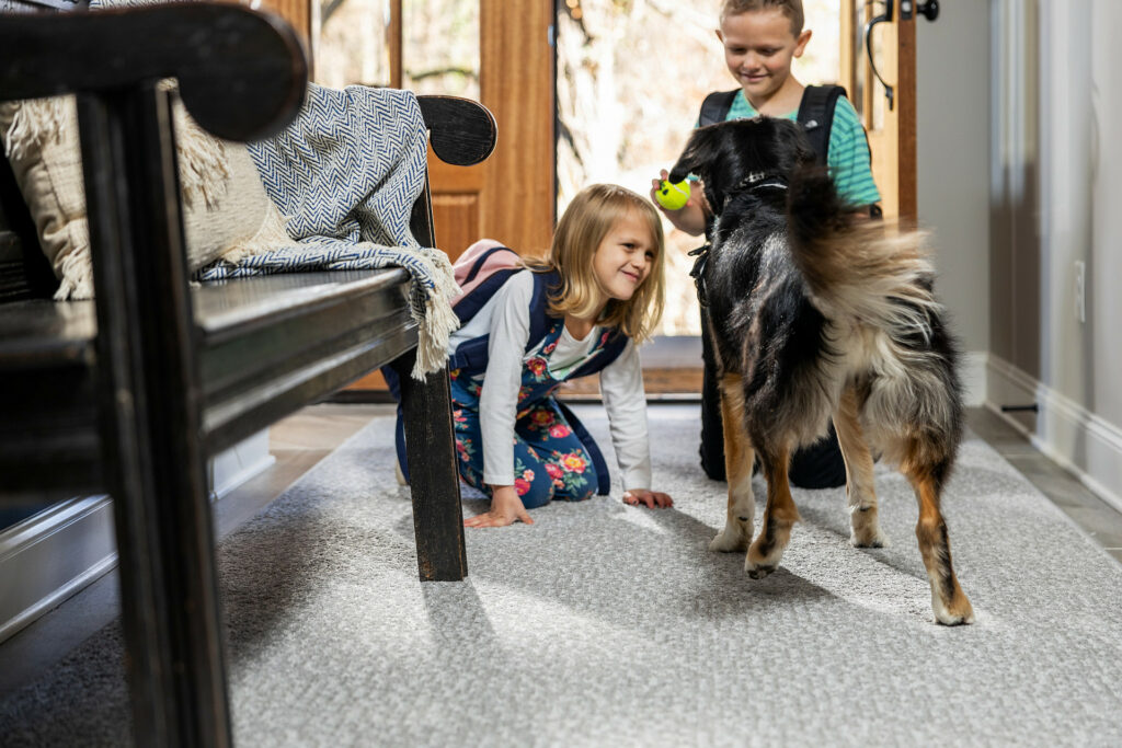 Kids playing with dog on carpet floors | Shoreline Flooring